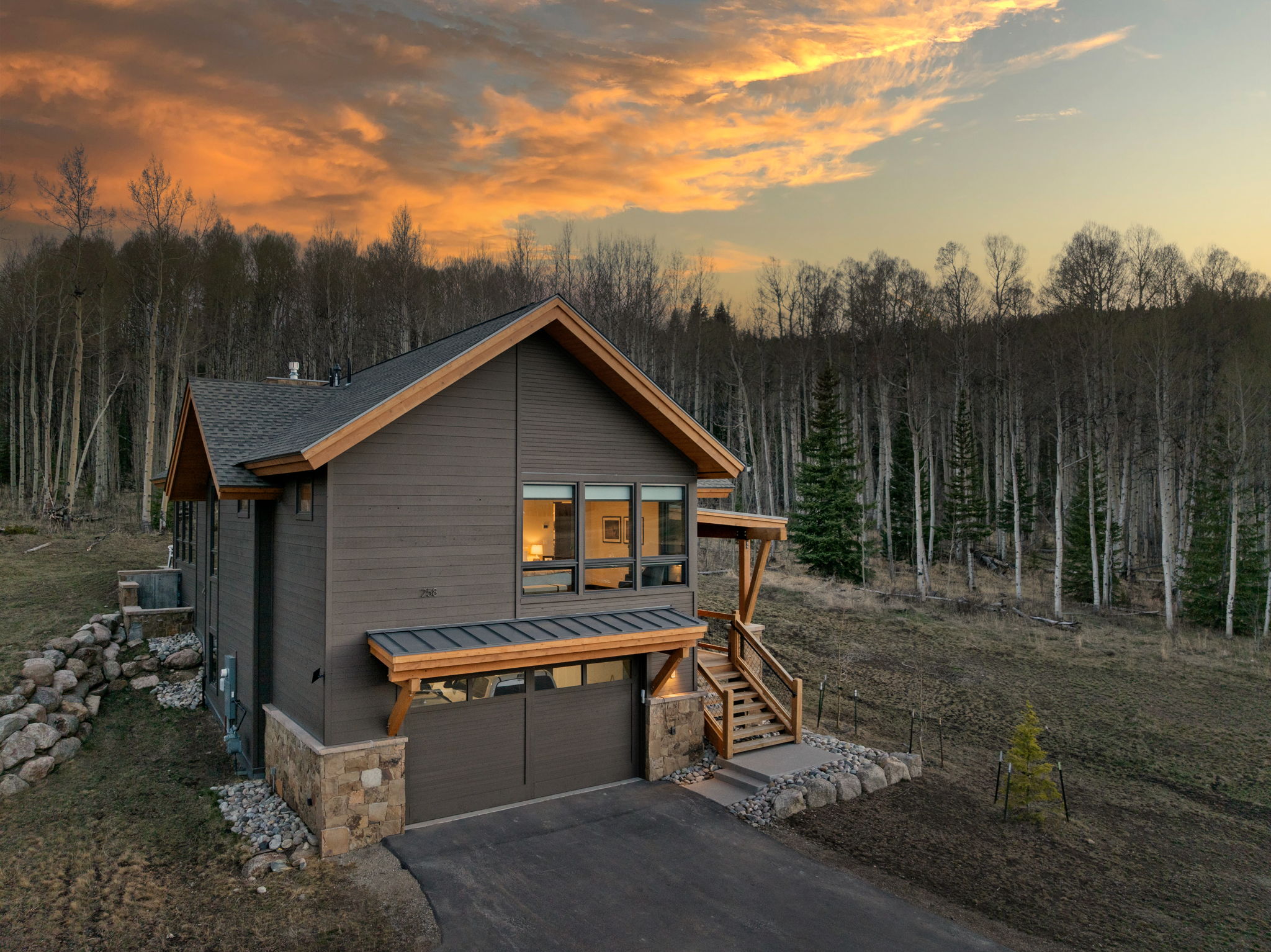 Lodge exterior at dusk with Aspen forest backdrop