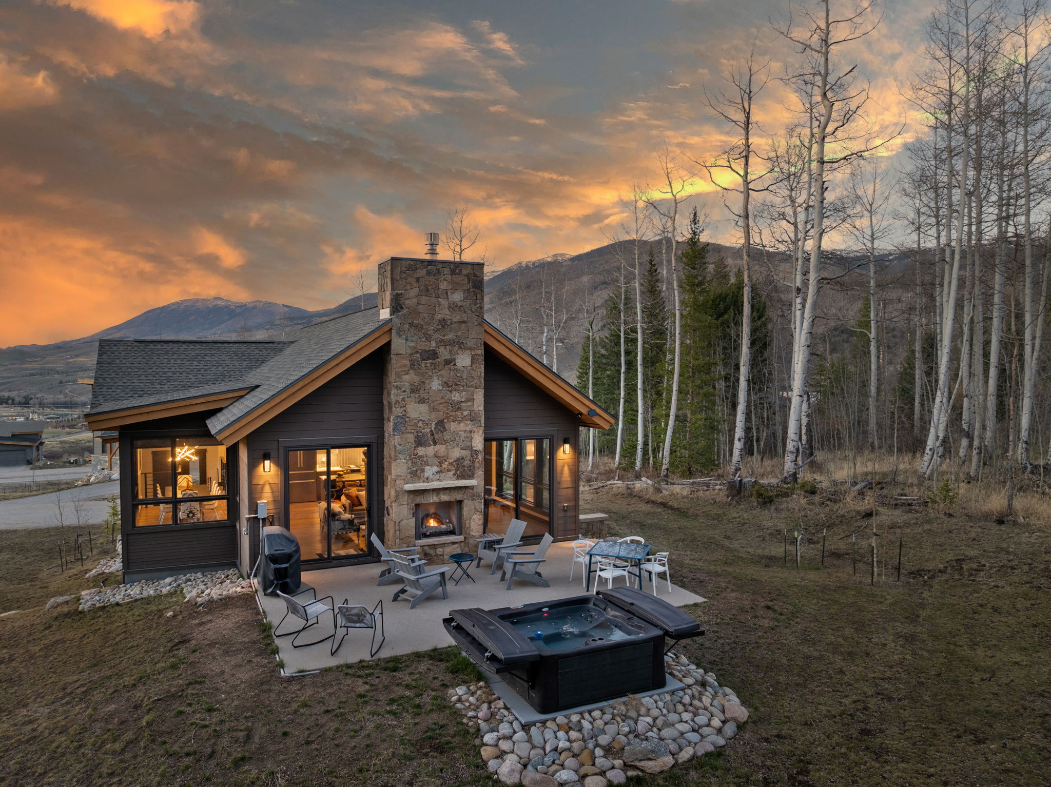 Rear patio, hot tub and outdoor fireplace at sunset