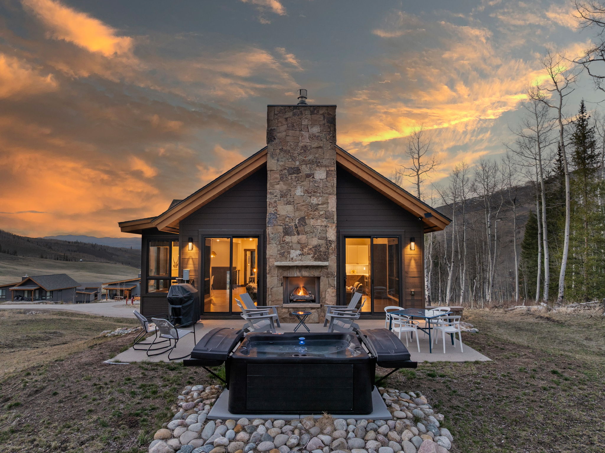 Hot tub and outdoor fireplace glowing at golden hour